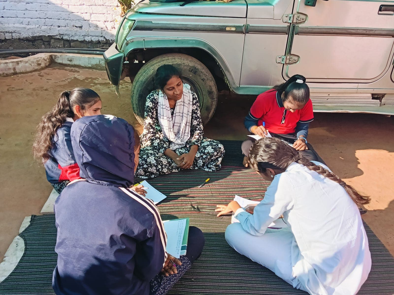Young women presenting community work in a village